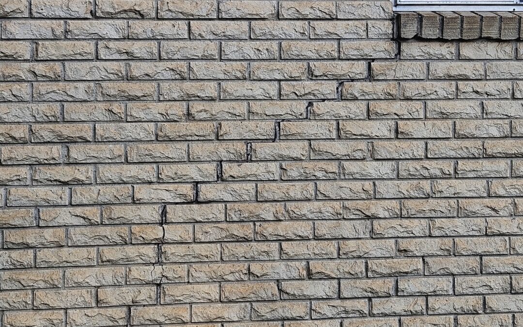 Stair-step cracks in brick wall of East Texas home caused by foundation shift.