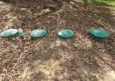 Septic system access lids and risers visible at ground level during a septic inspection on an East Texas property.