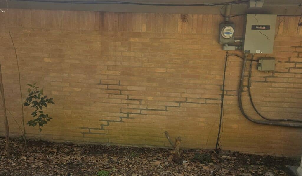 Significant stair-step crack in a brick exterior wall identified during a home inspection in White Oak, TX.
