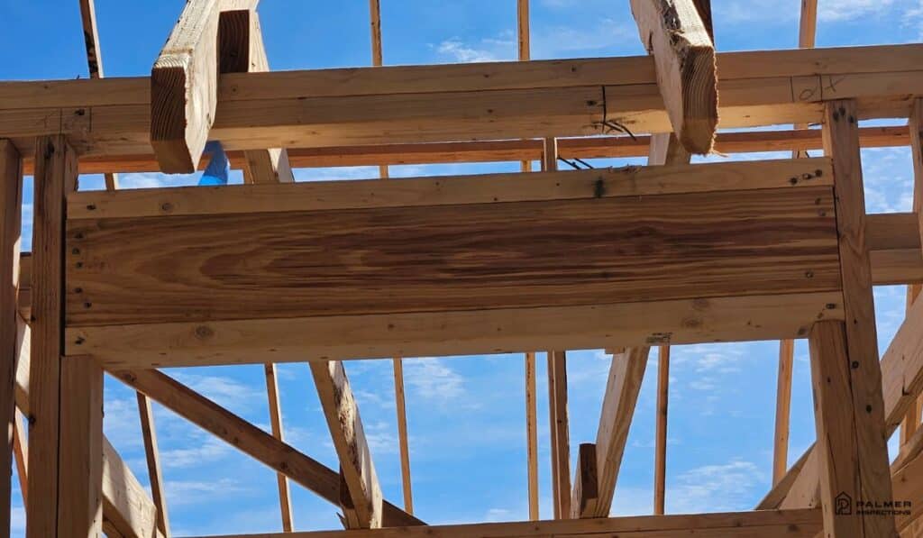 Close-up of wood headers and roof trusses during a new construction inspection in Longview, Texas.