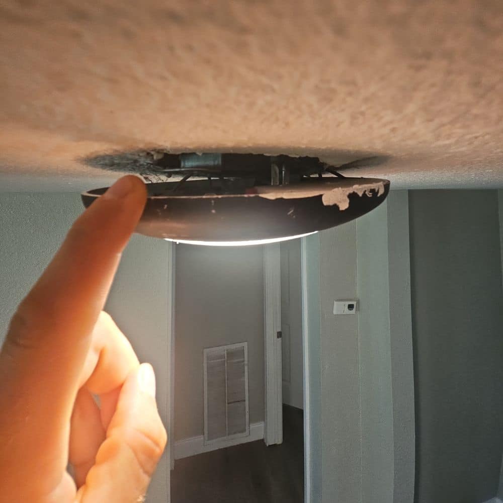 loose-ceiling-light-fixture-home-inspection-lindale-tx Palmer Inspections pointing out a loose, hanging ceiling light fixture during a residential home inspection in Lindale, TX.